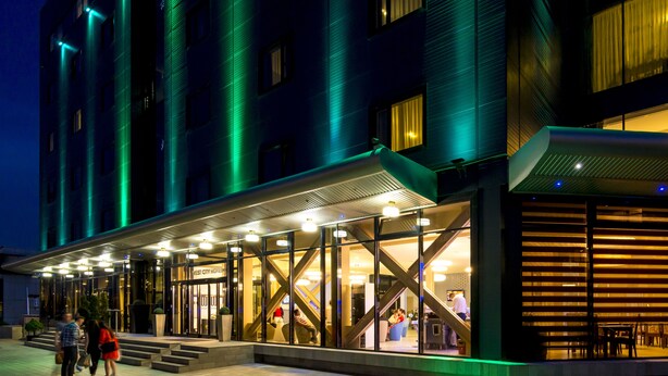 A hotel entrance with a covered outdoor area, glass doors, and a staircase leading to the entrance. - West City Hotel (Floresti)