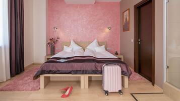 Une chambre à coucher avec un lit, une valise et une paire de chaussures posées sur le sol.