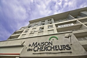 Ein Gebäude mit einem Schild, auf dem „la MAISON des CHERCHEURS“ und „Appart’ Hotel“ steht.