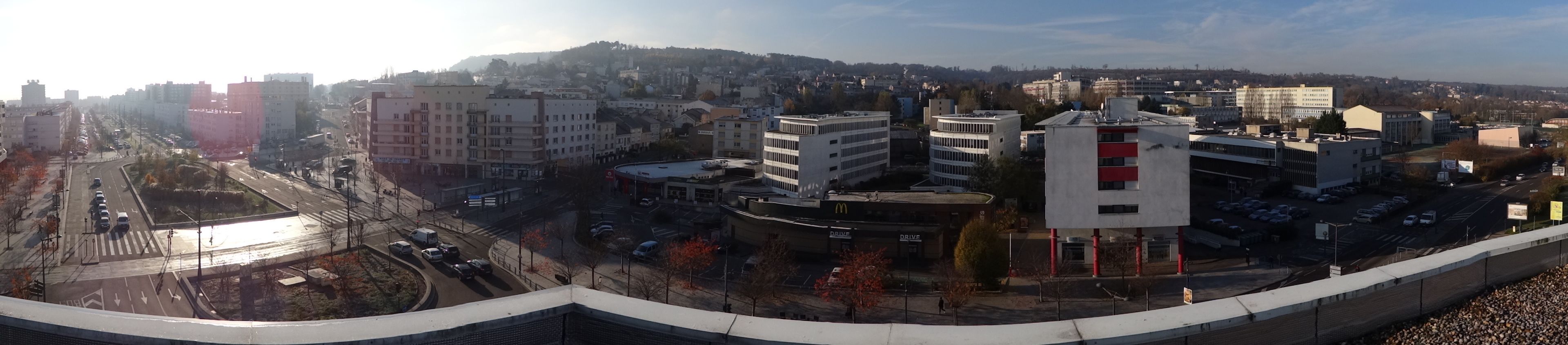 A cityscape with buildings, roads, and a McDonald's restaurant.
