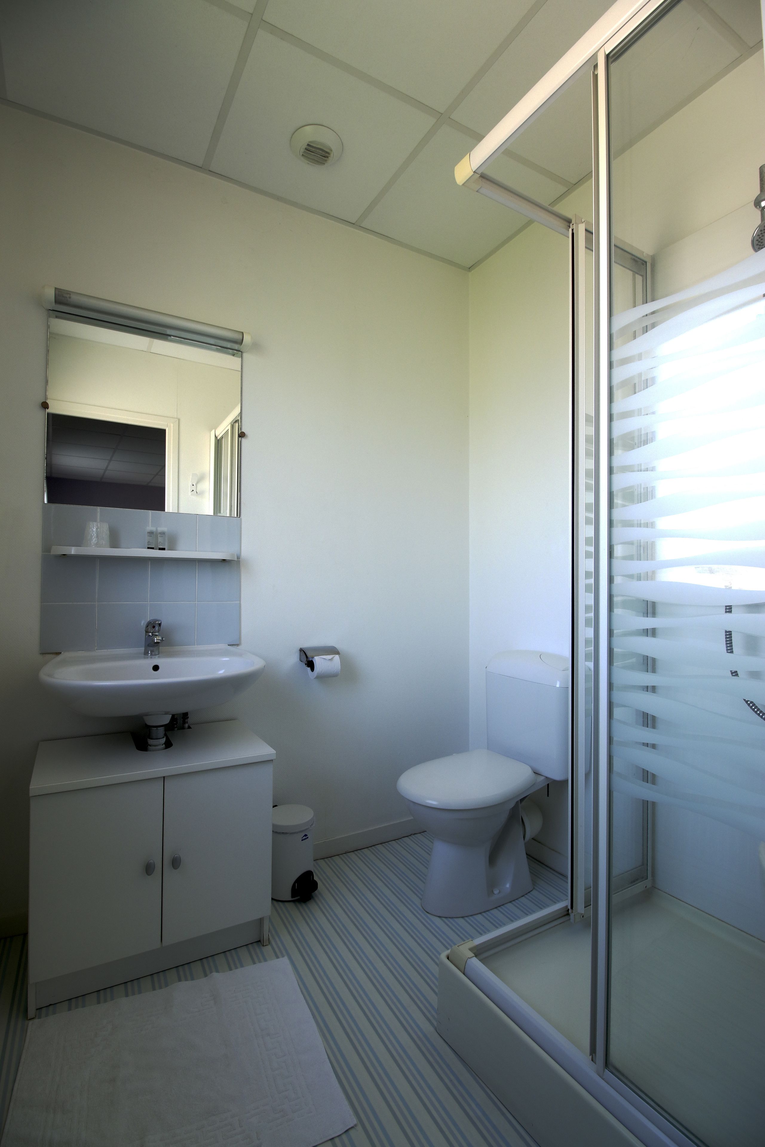 Ein Badezimmer mit Waschbecken, Toilette und Duschbereich.