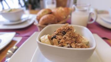 Un tazón de cereal con leche sobre un plato blanco.