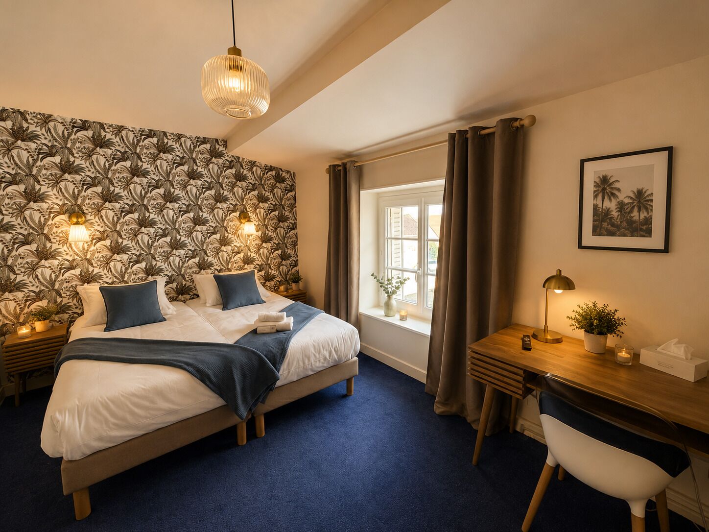 Une chambre à coucher comprenant un lit, des tables de chevet, un bureau, une chaise, une fenêtre avec des rideaux, un luminaire suspendu et un mur orné d’un motif floral.