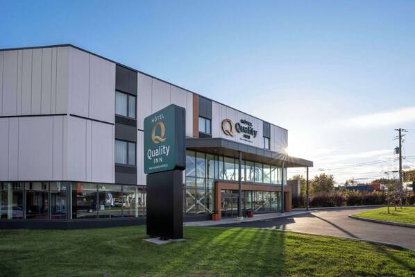 A modern hotel building with a prominent sign for 'Quality Inn' and 'Quality Hotel'.
