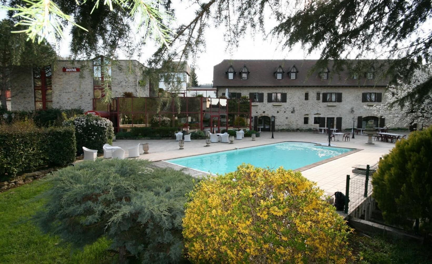 A hotel with a swimming pool, outdoor seating, and a garden area.