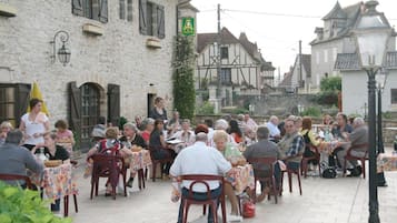 Un patio con mesas al aire libre donde personas están cenando.