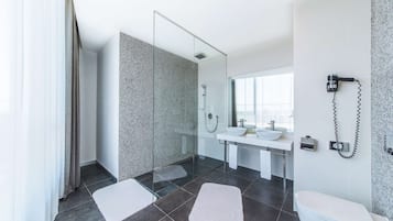 A modern bathroom with a glass shower, a white sink, and a toilet.