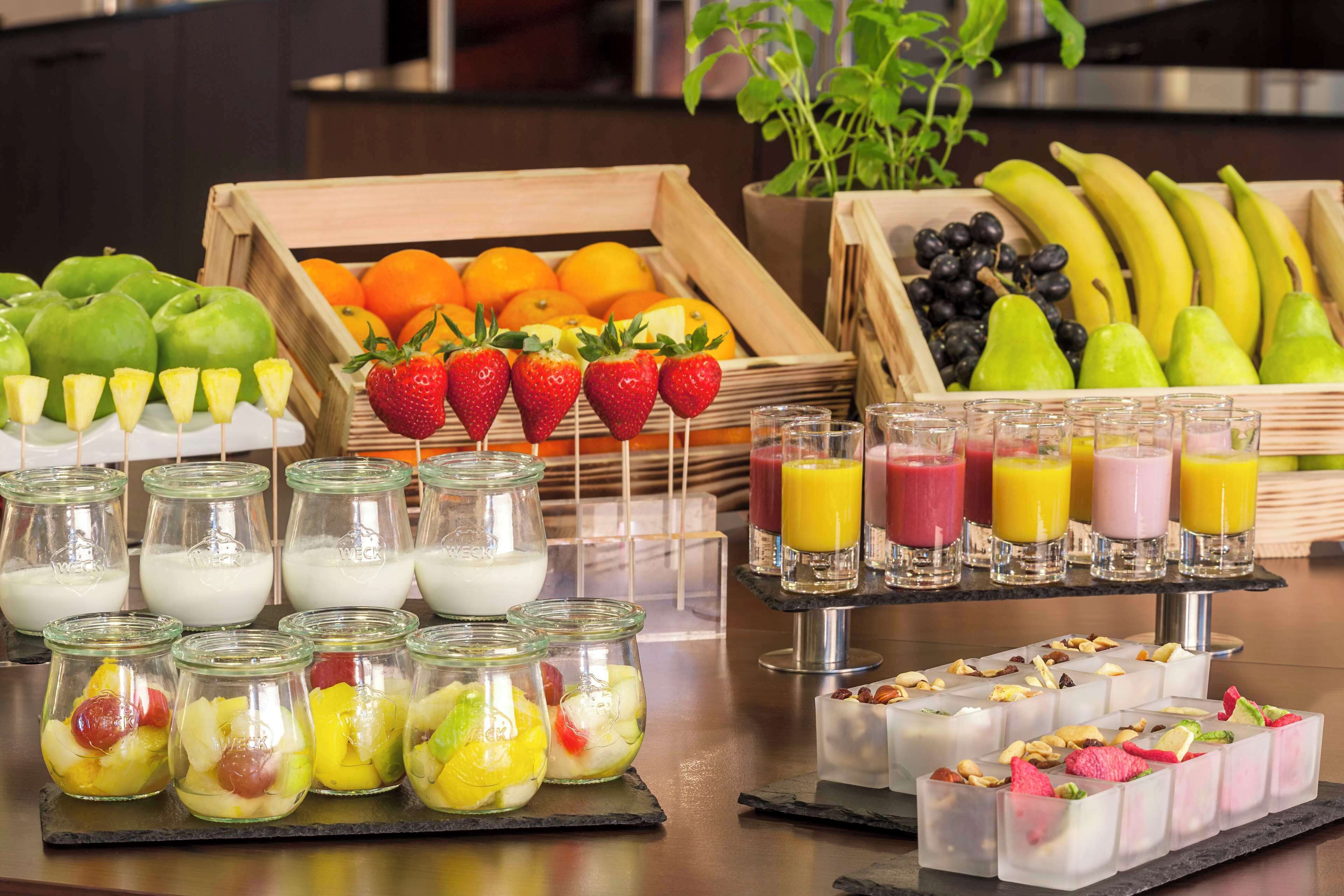 A breakfast buffet with various fruits, yogurt, and juices.