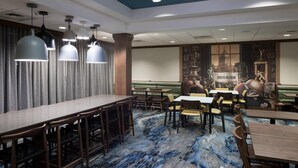 A restaurant with a long counter, booths, and a patterned floor.