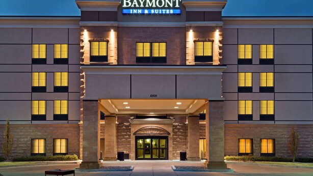 Edificio de Baymont Inn & Suites con entrada destacada, ventanas amplias y fachada bien iluminada.