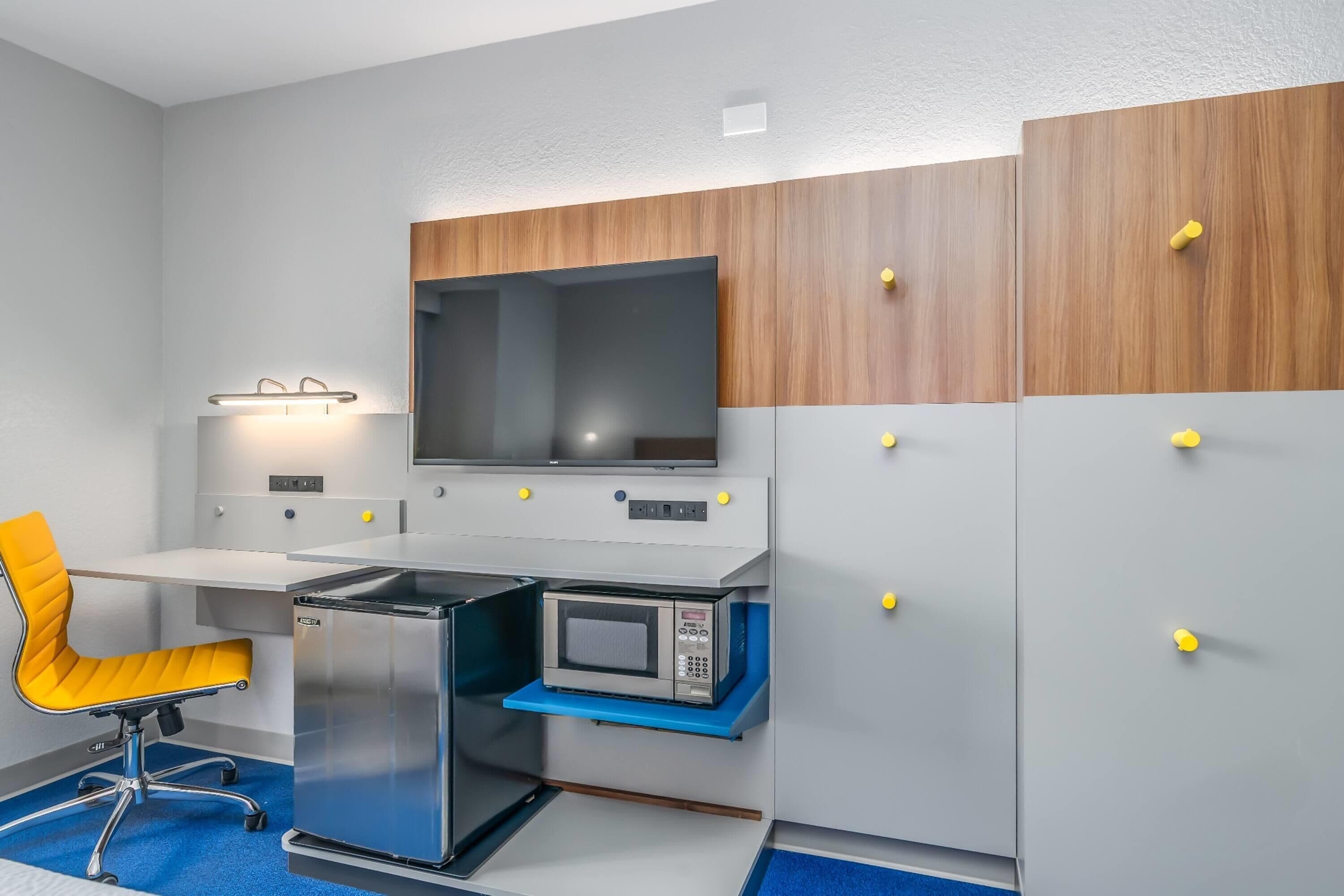A compact kitchenette with a microwave, stove, and sink.