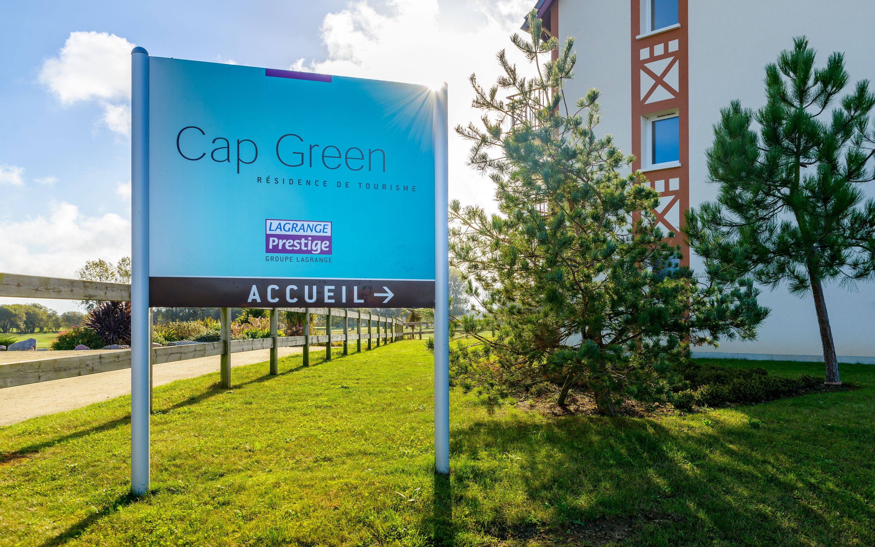 A sign for Cap Green, a hotel with a modern design, indicating the entrance direction.