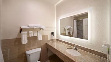 A bathroom with a toilet, a sink, a mirror, and a towel rack.
