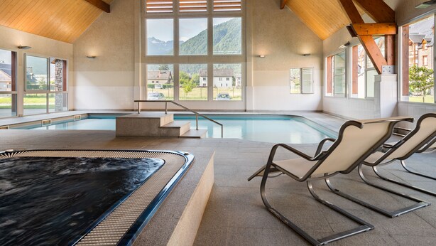 A large indoor swimming pool with a view of mountains through large windows. - Résidence Lagrange Vacances le Belvédère (Saint-Mamet)