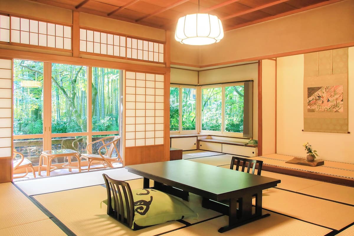 Ein traditioneller japanischer Raum mit Tatami-Böden, einem niedrigen Tisch und Schiebetüren.