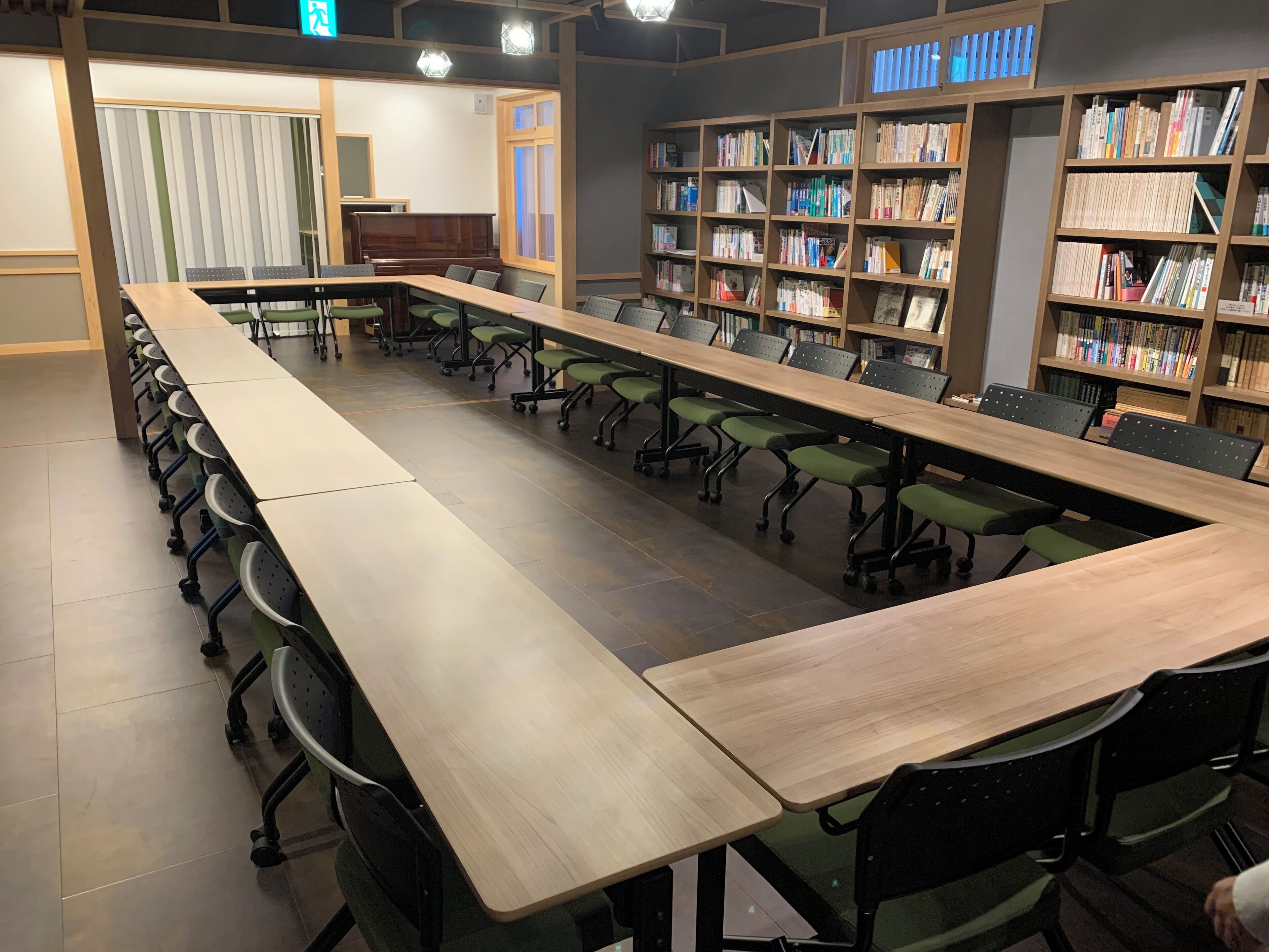 A conference room with a long table and chairs, surrounded by bookshelves.