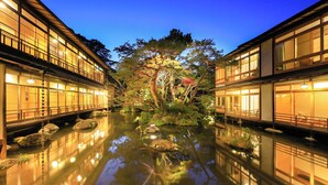 A traditional Japanese ryokan with a serene garden and a reflective pond. - Arai Ryokan (Izu)