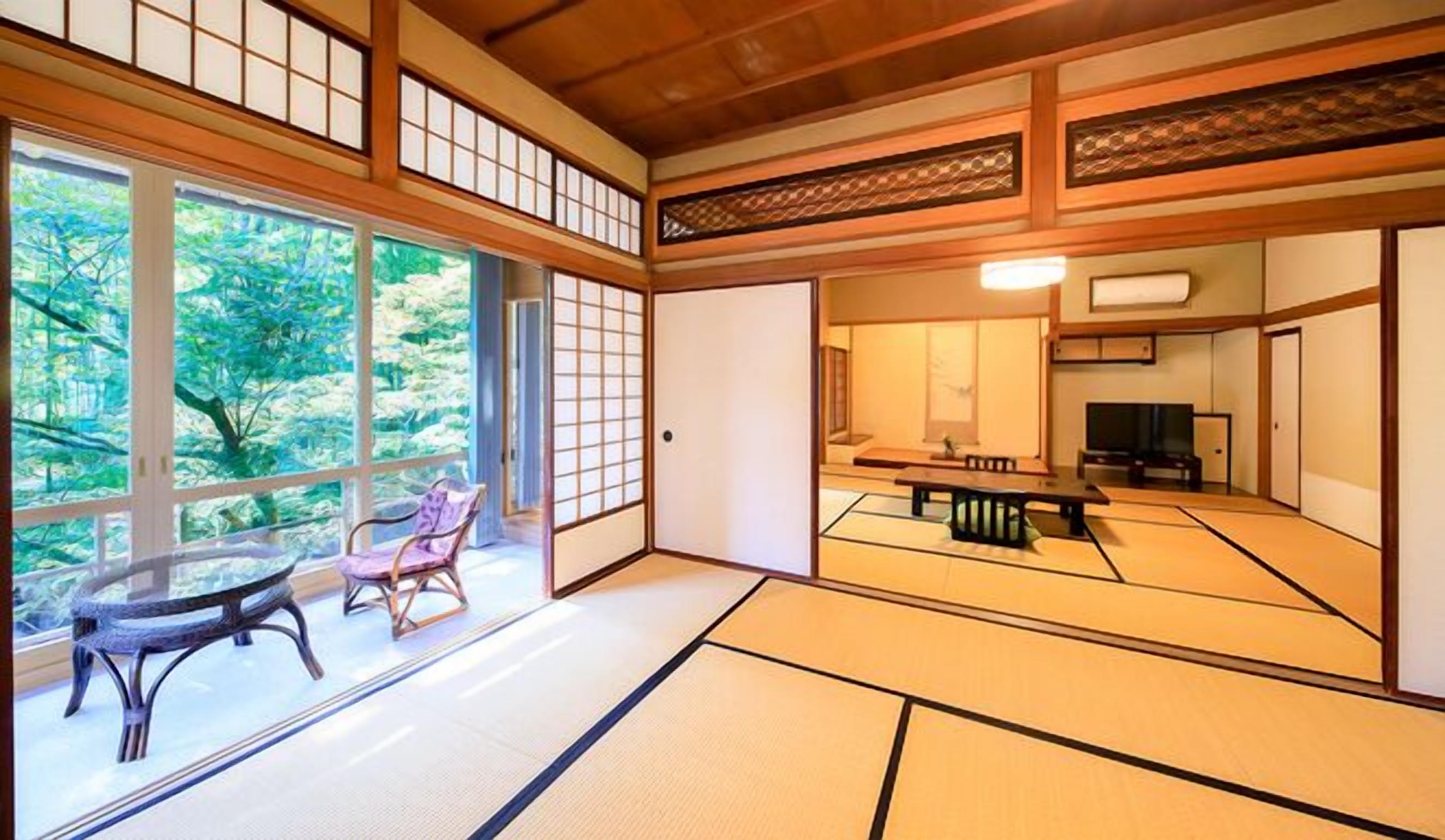 A traditional Japanese room with tatami flooring, a low table, a chair, and a sliding door.