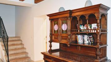 Une bibliothèque en bois dotée de plusieurs étagères, d’un plateau en marbre et de panneaux de verre décoratifs.