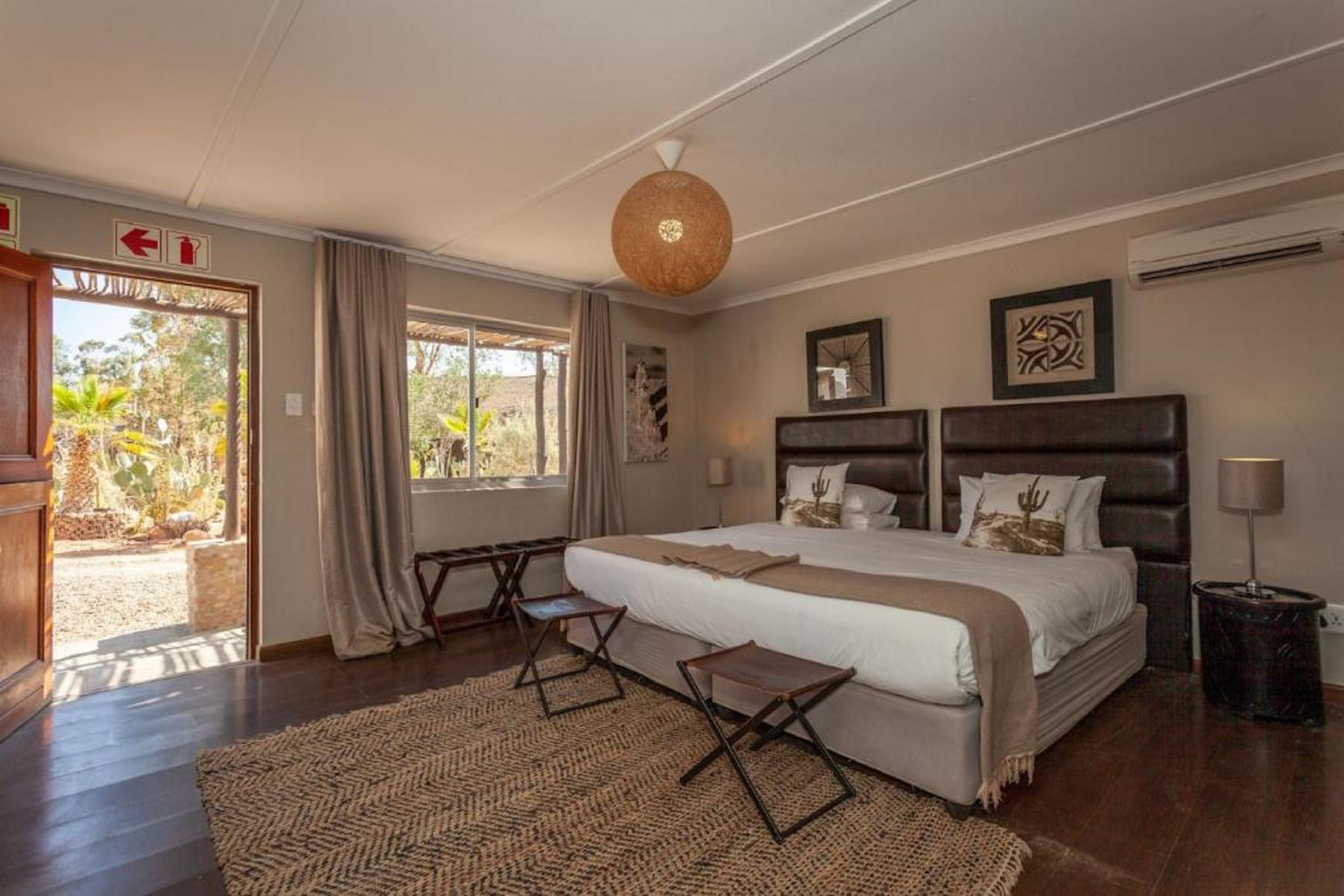 A spacious bedroom with a large bed, a desk, and a view of the outdoors.