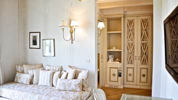 A bedroom with a bed, bedside lamps, a wardrobe, and a small table.