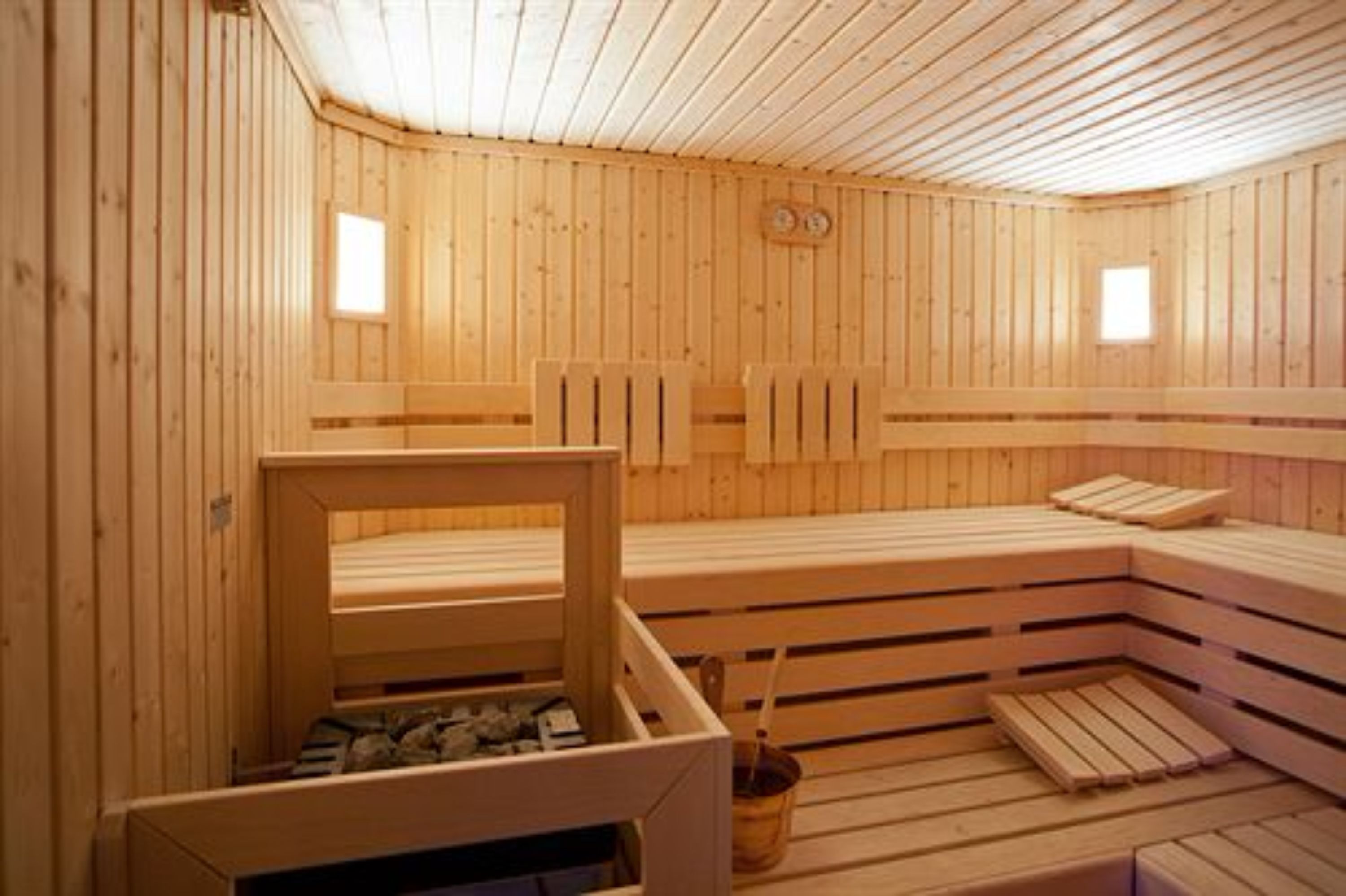 Una sauna con panche in legno e un piccolo tavolo con un catino.