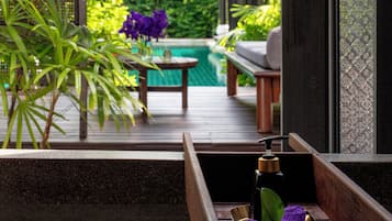 Relax in a serene garden oasis with a tranquil pool view, surrounded by lush greenery and a soothing water feature.