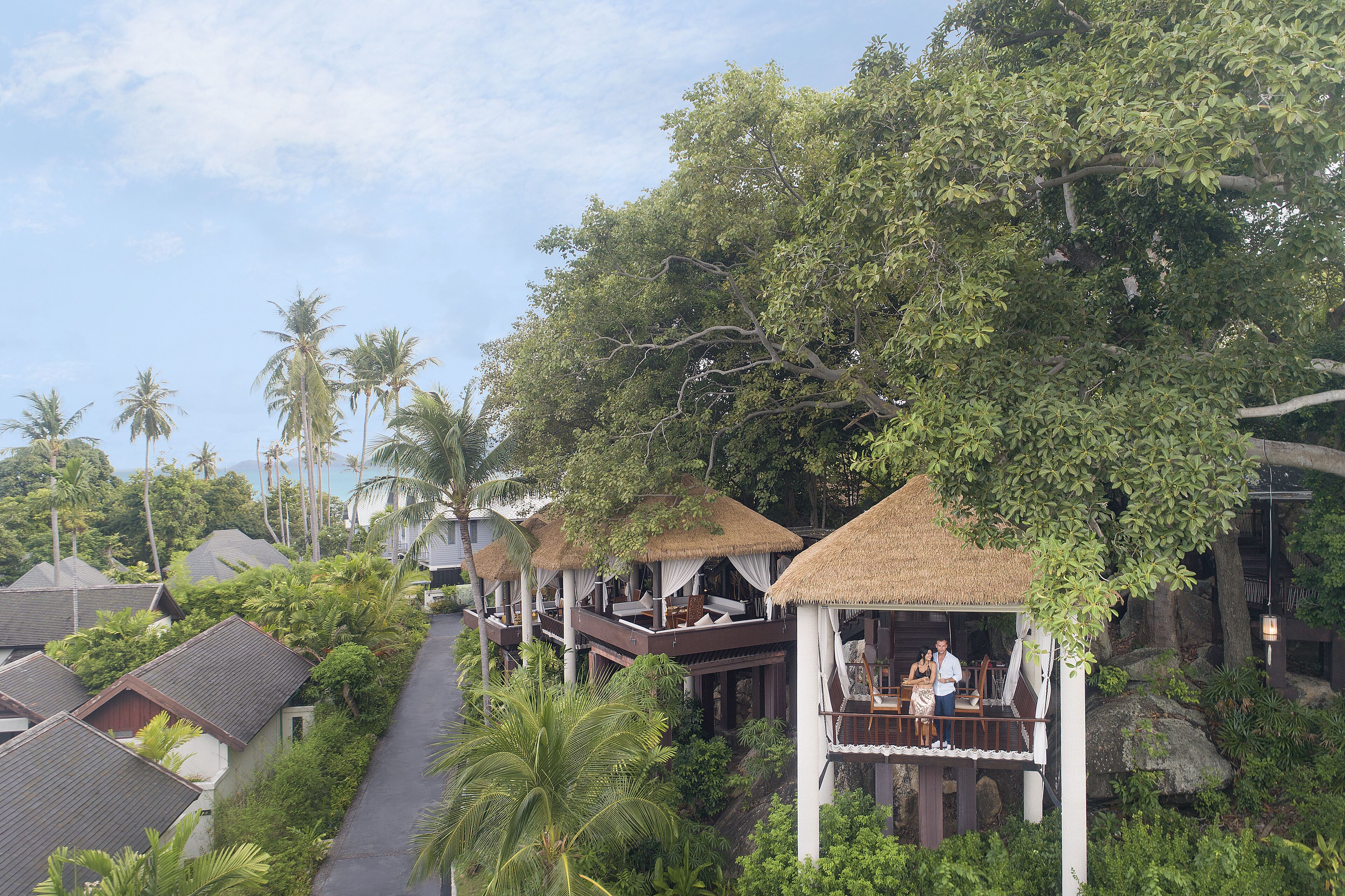 A resort with overwater bungalows, thatched roofs, and lush tropical vegetation.
