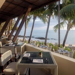 Guests can dine al fresco with ocean views under a shaded roof.