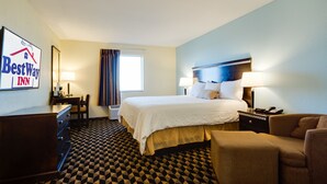A hotel room with a large bed, a desk, a chair, a dresser, and a sign for BestWay Inn. - Best Way Inn Cleburne TX (Cleburne)