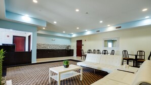 A modern hotel lobby with a check-in counter, seating area, and a large white sofa. - Best Way Inn Cleburne TX (Cleburne)