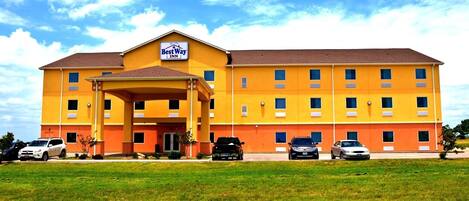 Un Best Way Inn con fachada amarilla, varios pisos y una entrada cubierta.
