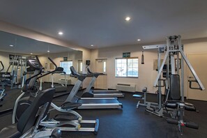 A gym with treadmills, a weight machine, and a mirror.
