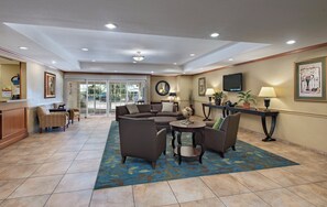 A hotel lobby with a seating area, a reception desk, and a television mounted on the wall. - Candlewood Suites Austin N - Cedar Park by IHG (Cedar Park)