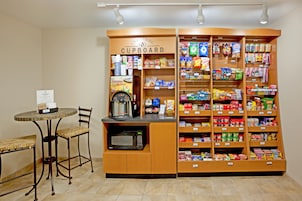 Una zona de kitchenette con microondas, cafetera y una pequeña mesa con sillas.