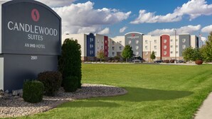 Une enseigne d’hôtel pour Candlewood Suites, qui fait partie de la chaîne hôtelière IHG, avec un ciel dégagé et une pelouse bien entretenue à l’avant.