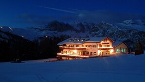 Un hôtel à deux étages, dont le toit est recouvert de neige, situé dans une région montagneuse.