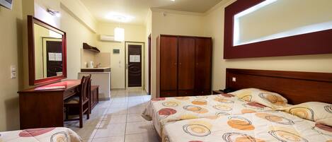Une chambre d’hôtel avec deux lits, un bureau, une chaise, une armoire et un miroir.