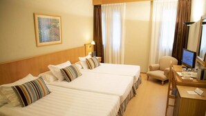 A hotel room with two beds, a desk with a computer, a chair, and a lamp. - Alda Castelao (Vilagarcia de Arousa)
