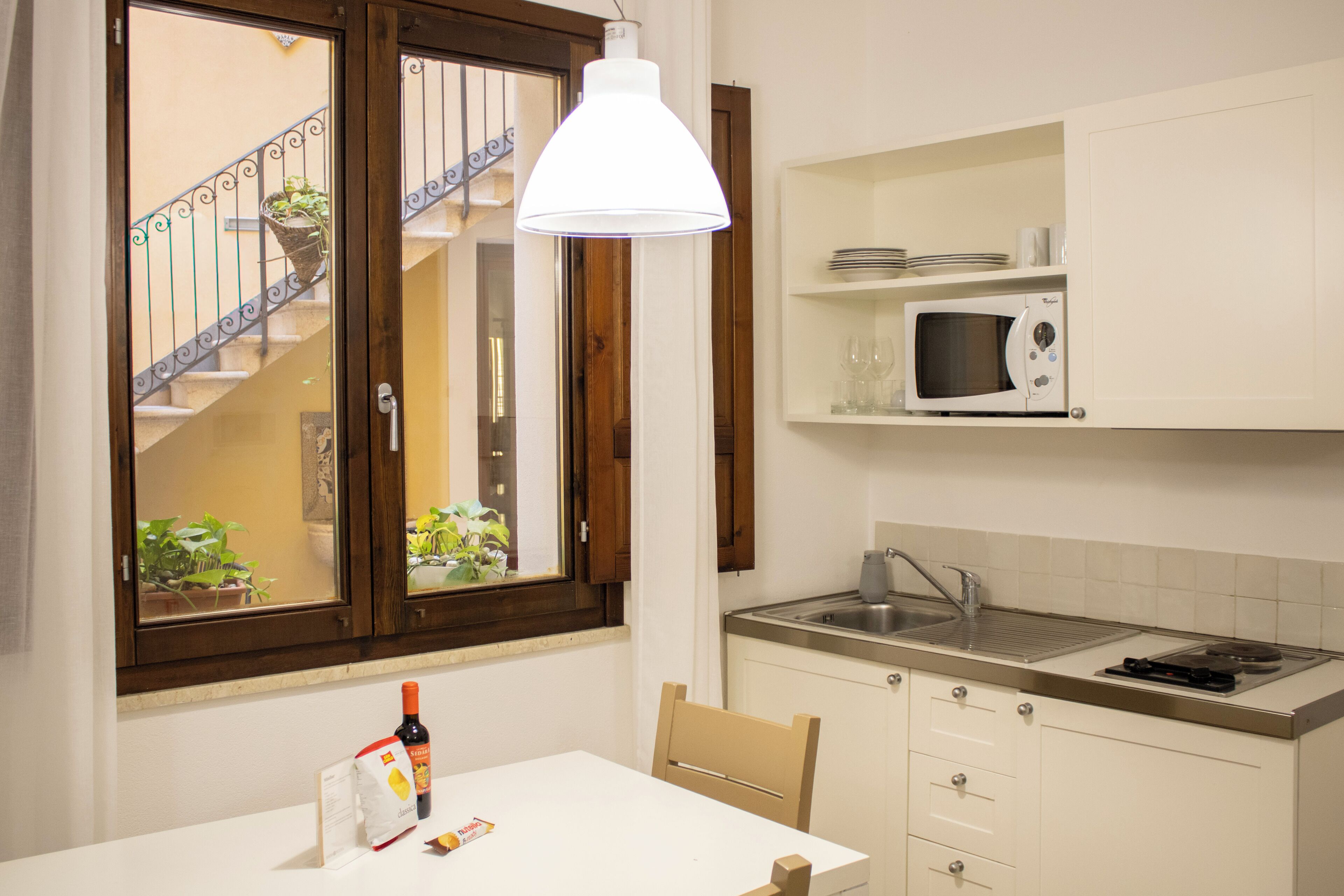 A kitchen with a white table, a microwave, and a sink.