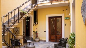 Un patio con escaleras, asientos al aire libre y una puerta con letrero de salida.