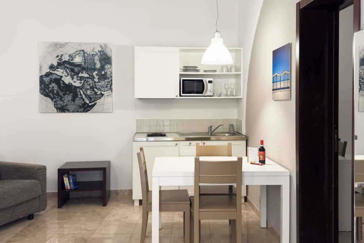 Un espacio habitable compacto con comedor, kitchenette y sofá.