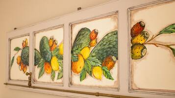 Una pared con tres cuadros enmarcados de frutas y verduras.
