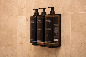 Tres ampolles de productes Elemental Herology sobre una paret.