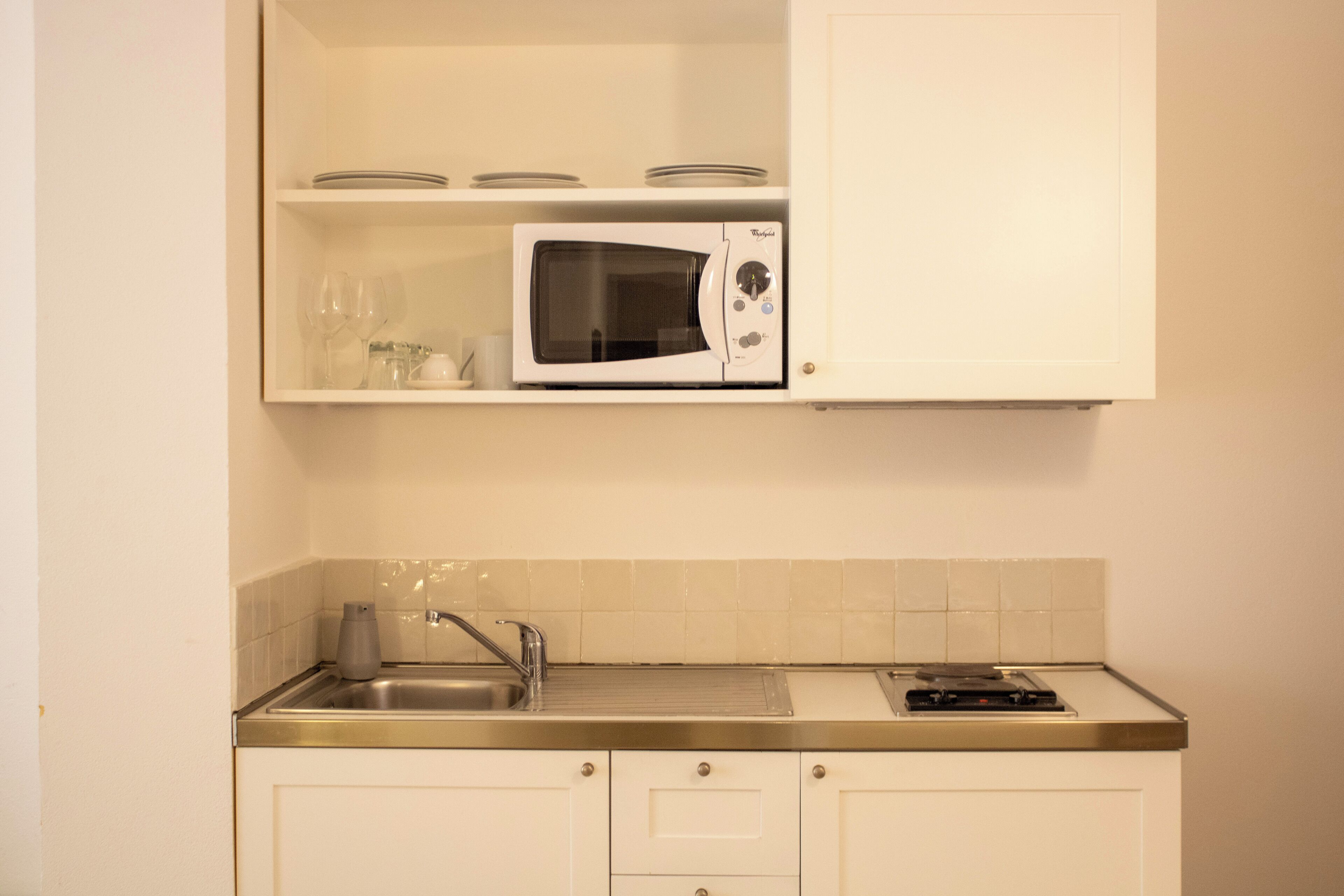 A compact kitchen with a microwave, a sink, and a small countertop.