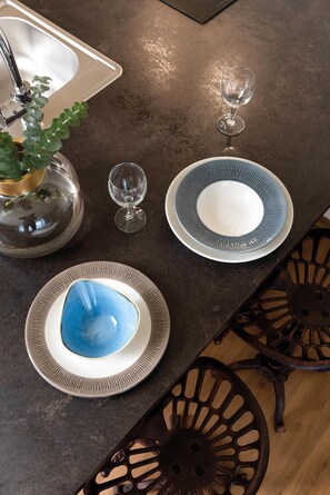 Enjoy a stylish dining experience with a dark-toned table and two ornate chairs.