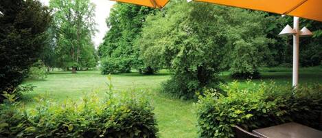 An outdoor patio area with a view of a grassy park.