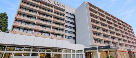 Un hôtel à plusieurs étages, reconnaissable à son grand panneau « SEMINARIS », à sa façade moderne et à son entrée située au niveau du sol.