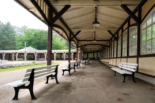 A covered pavilion with benches and large windows.
