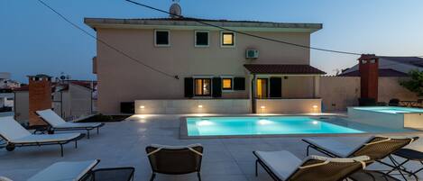 Een buitenzwembad, een verwarmd zwembad en parasols bij het zwembad